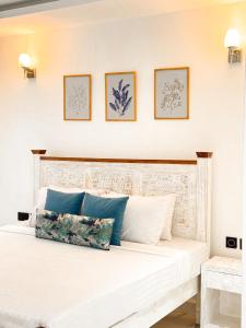 a white bed with two pillows on top of it at Uttoru Creek Villa-2 in Mombasa +21 photos