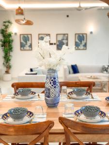 a wooden table with a blue and white vase with flowers at Uttoru Creek Villa-2 in Mombasa