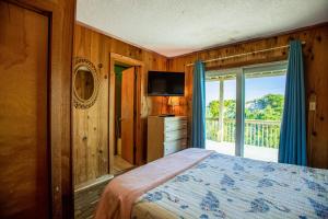 a bedroom with a bed and a balcony with a television at AVWI1 Beach Stars #1-WI in Avon