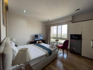 a bedroom with a large bed and a red chair at Pyramids Sunshine View in Giza