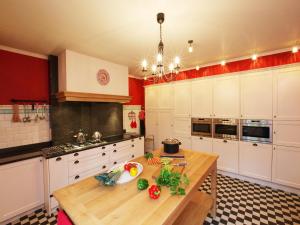 a kitchen with white cabinets and a wooden table at Group Villa with Pool & Sauna in Wanze