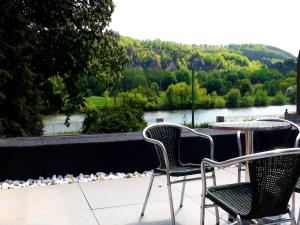 two chairs and a table with a view of a river at Group Villa with Pool & Sauna in Wanze