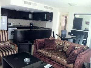 a living room with a couch and a kitchen at Torino Apartments شقق تورينو in Amman
