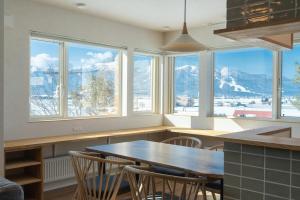 a kitchen with a table and chairs and windows at torinuma VILLA in Furano