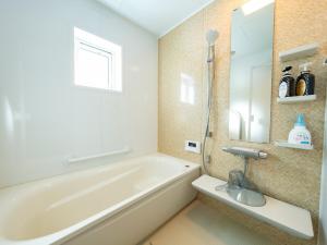 a bathroom with a bath tub and a sink at torinuma VILLA in Furano +81 photos