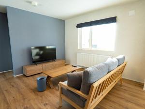 a living room with a couch and a tv at torinuma VILLA in Furano
