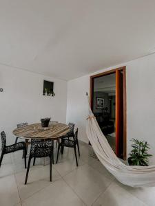 a hammock in a living room with a table and chairs at Suítes em casa ampla com área gourmet in Uberlândia
