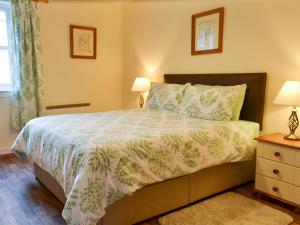 a bedroom with a bed and two lamps and a window at Ashley Cottage in Bowmore +16 photos