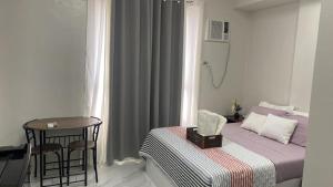 a small room with a bed and a table and chair at Gem's Silid Tulugan in Cebu City