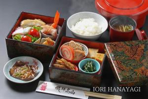 three boxes of food on a table with rice at IORI Stay in Takayama