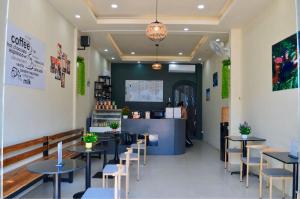 a restaurant with tables and chairs and a counter at Aroma Hostel in Vientiane