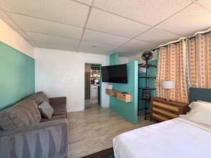 a room with a bed and a couch and a tv at Arvilla Resort in St. Pete Beach