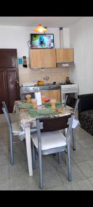 a kitchen with a table with chairs and a tv at Alquileres BH in La Rioja