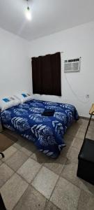 a bedroom with a bed with a blue blanket at Alquileres BH in La Rioja