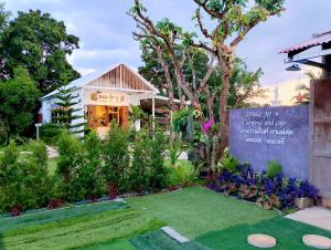 a garden with a sign in front of a house at Bake for You Camping in Ban Nong Bua