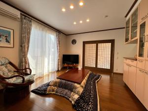 a living room with a couch and a table at Beachfront Irori in Suo Oshima