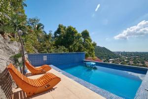 a swimming pool with two lounge chairs on top of a house at Hillside Haven in Kingston