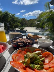 a table topped with a plate of tomatoes and vegetables at Villa Gaspar Terrazas in Playa hermosa