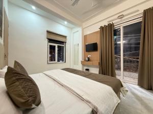 a bedroom with a large bed and a window at Hotel Krishna Tulsi Van - Near Bankey Bihari & ISKCON in Vrindāvan