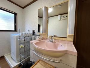 a bathroom with a sink and a large mirror at Beachfront Irori in Suo Oshima