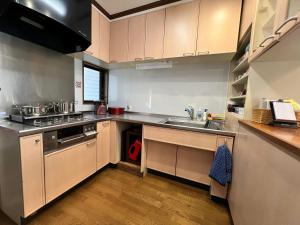 a kitchen with a sink and a stove at Beachfront Irori in Suo Oshima