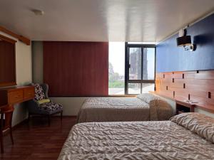 a hotel room with two beds and a desk and a window at Hotel Gilfer Puebla Centro Histórico in Puebla +286 photos