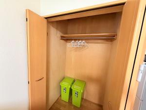two green bins are sitting in a closet at サクセスハイム 203 in Miyazaki