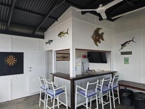 a bar in a room with white walls and blue chairs at Howsthaserenitee - 3BR house with bay views in Coffin Bay
