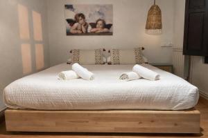 a bedroom with a bed with white sheets and pillows at La casina de Barro in Llanes