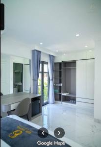 a white kitchen with a desk and a table at 6668 Hotel - Chi nhánh 2 in Tây Ninh