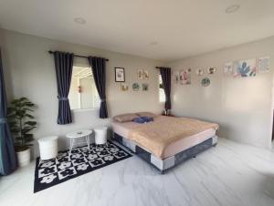 a bedroom with a bed and a table in it at Bake for You Camping in Ban Nong Bua