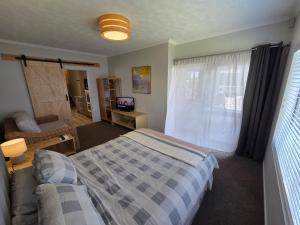 a bedroom with a bed and a couch and a window at Links View Retreat in Omokoroa