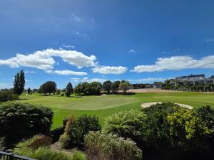 a view of a golf course with a green at Links View Retreat in Omokoroa