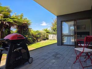 a stroller on a patio with a table and chairs at Links View Retreat in Omokoroa