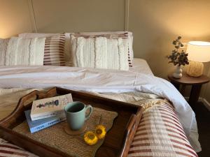 a bed with a tray with a cup and flowers on it at Kangaroo Cottage in Hay
