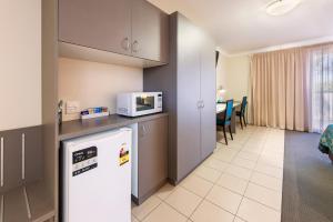 a kitchen with a refrigerator and a microwave at Royal Motel Miles in Miles
