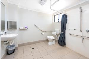 a bathroom with a sink and a toilet and a shower at Royal Motel Miles in Miles +36 photos