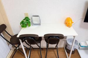 a white table with two chairs and a phone on it at ひまわり in Dazaifu +13 photos
