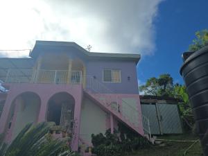 a pink and white house with a staircase at Jay's Guest House II in Epping Farm