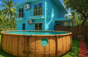 a house with a large wooden tub in front of a house at Irida 2bhk private pool viila in Assagao