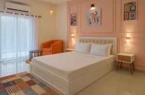 a bedroom with a large white bed and a chair at Irida 2bhk private pool viila in Assagao +10 photos