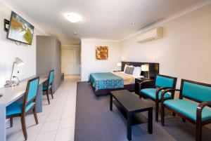 a hotel room with a bed and a table and chairs at Royal Motel Miles in Miles