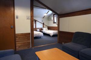 ein Zimmer mit zwei Betten und einer Couch in der Unterkunft miscu in Minakami