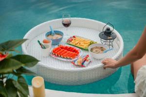 a white wicker table with food and a glass of wine at Monsaan ม่อนซาน in Mon Jam