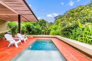 a swimming pool with two chairs and a table and a house at Juntas del Lago - Casa 3 in Apulo +37 photos