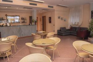 un restaurante con mesas y sillas y un sofá en Albergo Munsci', en Rovello Porro