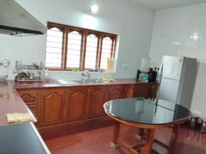 a kitchen with a glass table and a refrigerator at Mansion Du Lac in Kottayam +27 photos