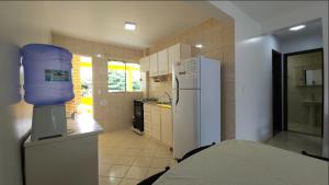 a kitchen with a white refrigerator and a sink at Pousada Vila ÁguaMar in Itapoa