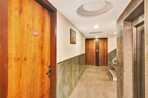 a hallway with a wooden door and a staircase at Hotel O Avi Suites in New Delhi