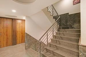 a winding staircase in a home with a stone wall at Hotel O Avi Suites in New Delhi +25 photos